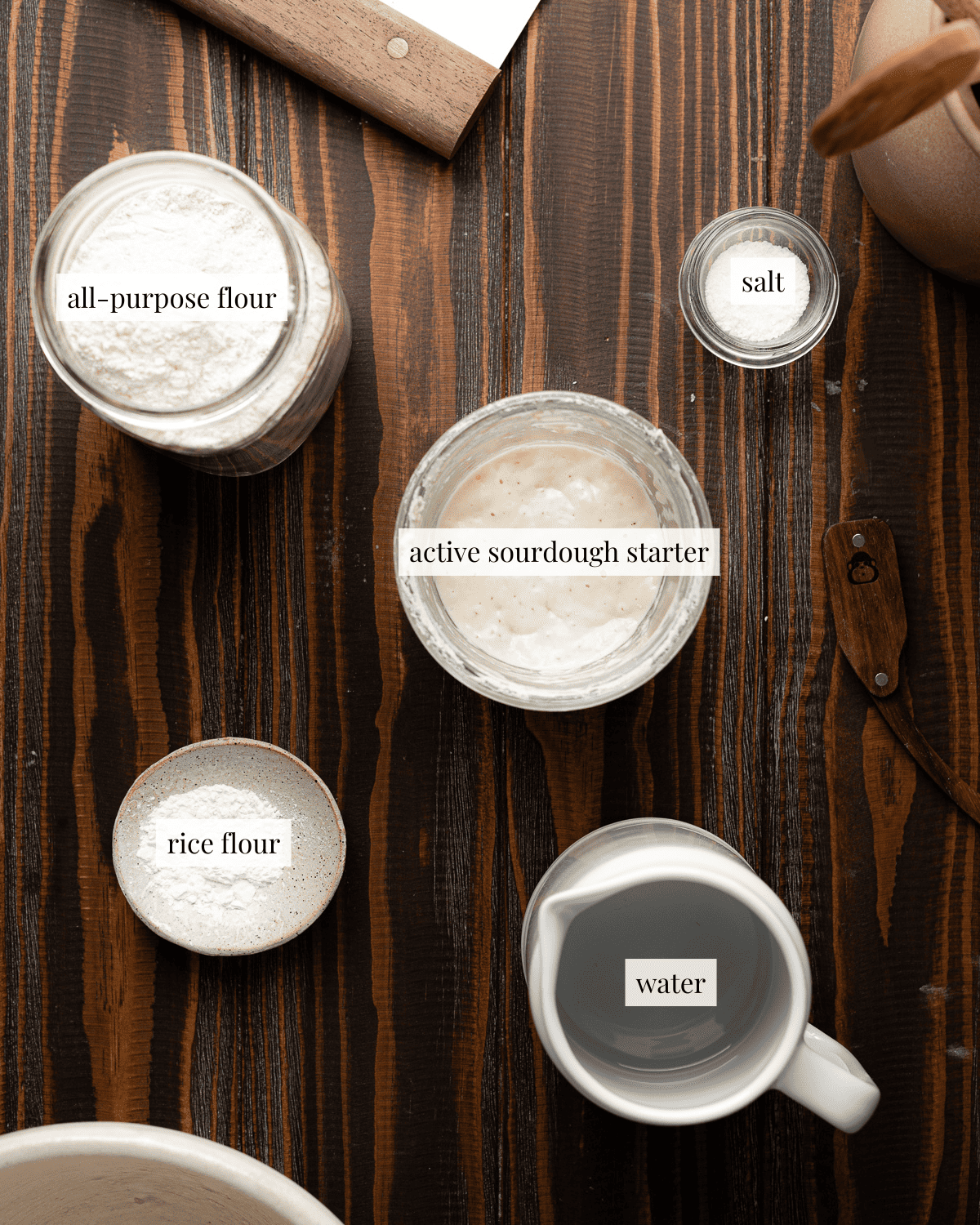 Ingredients for all-purpose flour sourdough in containers. All-purpose flour, water, salt, active sourdough starter and rice flour. 