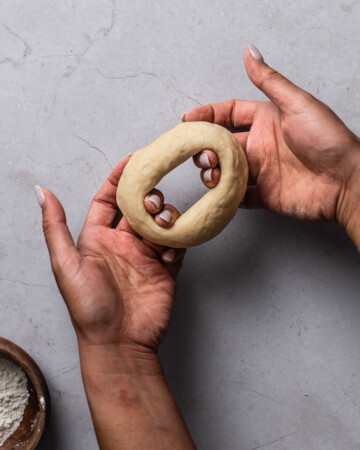 Hands shaping bagel dough