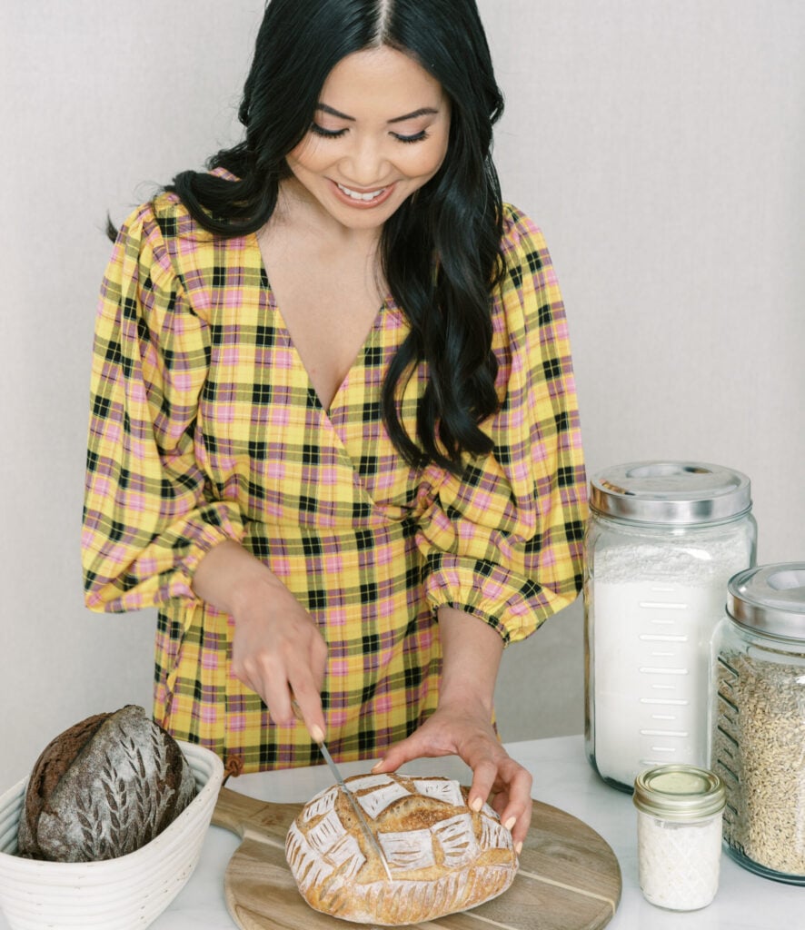 Hannah Dela Cruz slicing loaf of sourdough bread