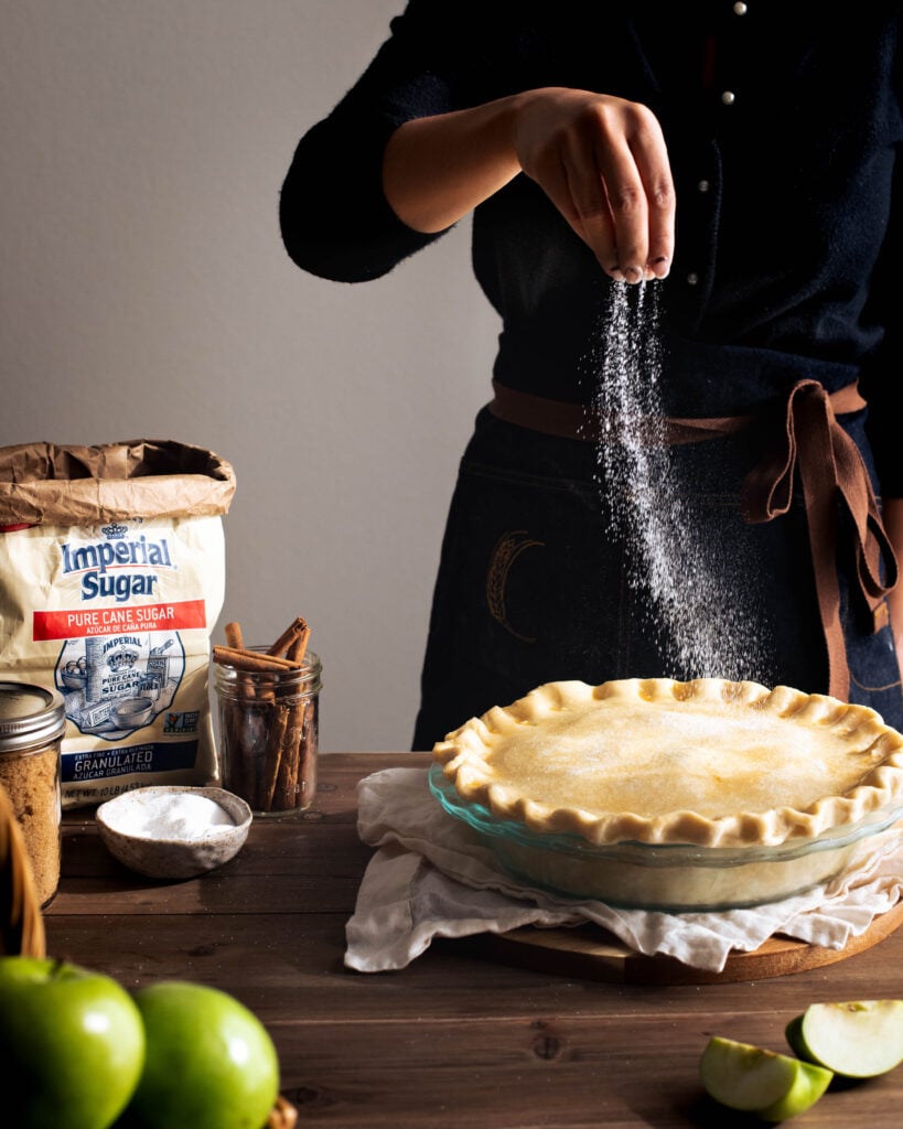 Sprinkling sugar on top of unbaked apple pie