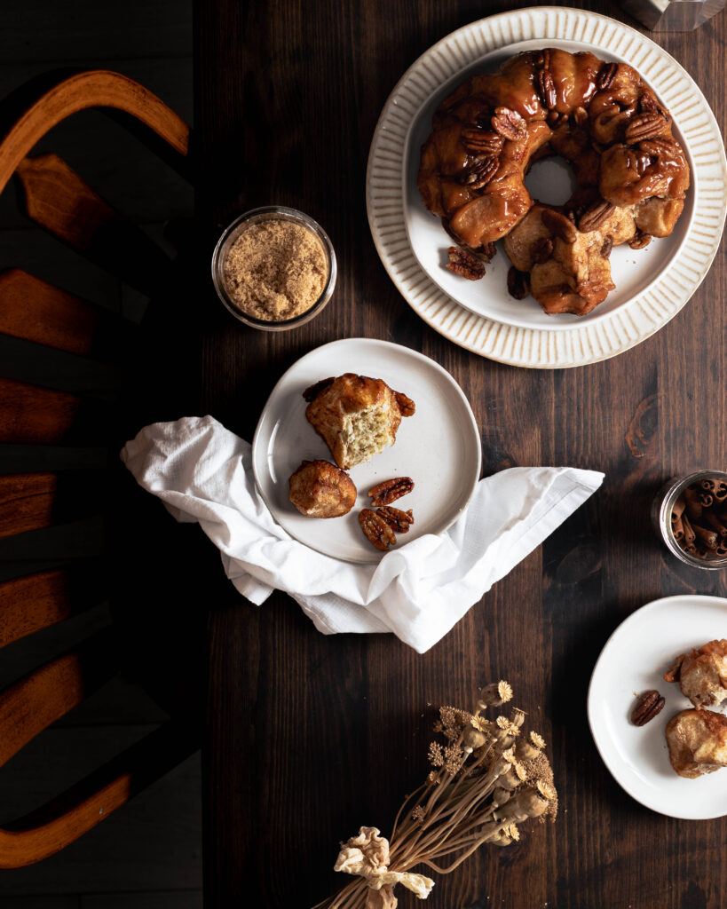 Table scene with baked monkey bread and pieces of fluffy bread torn from the loaf
