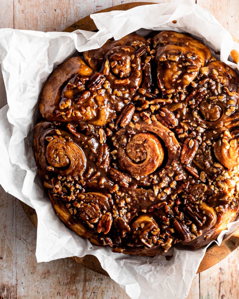 Close up shot of a tray of sticky buns topped with caramel and nuts