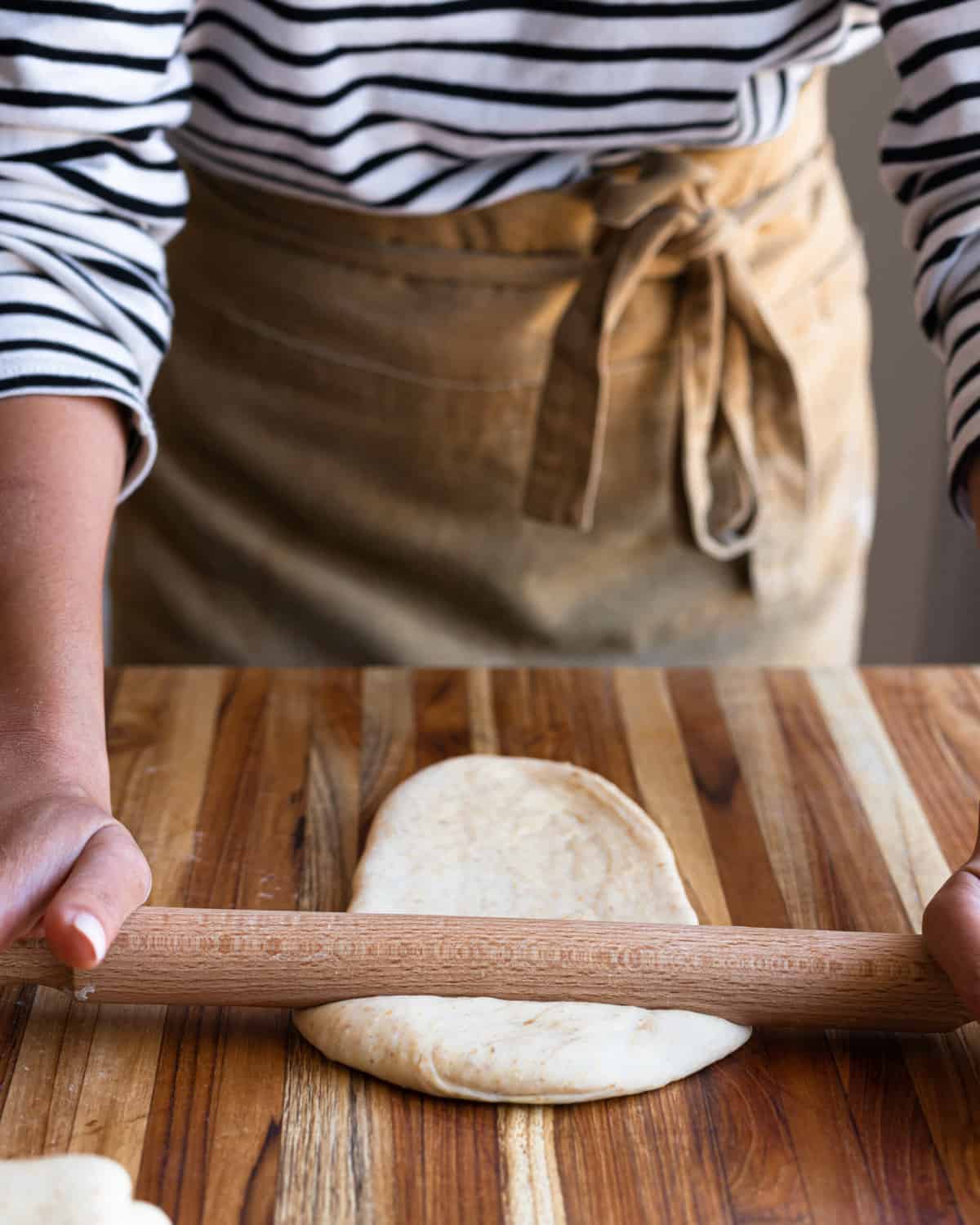 Flattening 1 portion of dough using a rolling pin