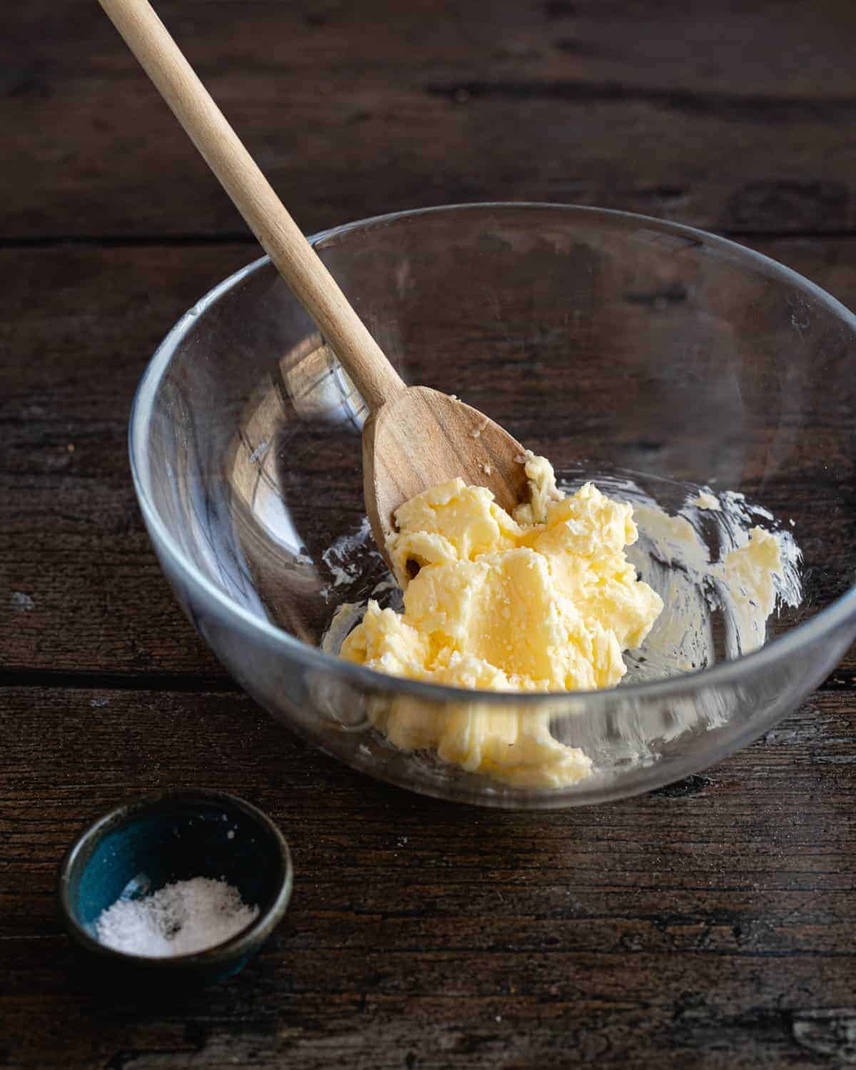 stirring salt into fresh homemade butter with a wooden spoon