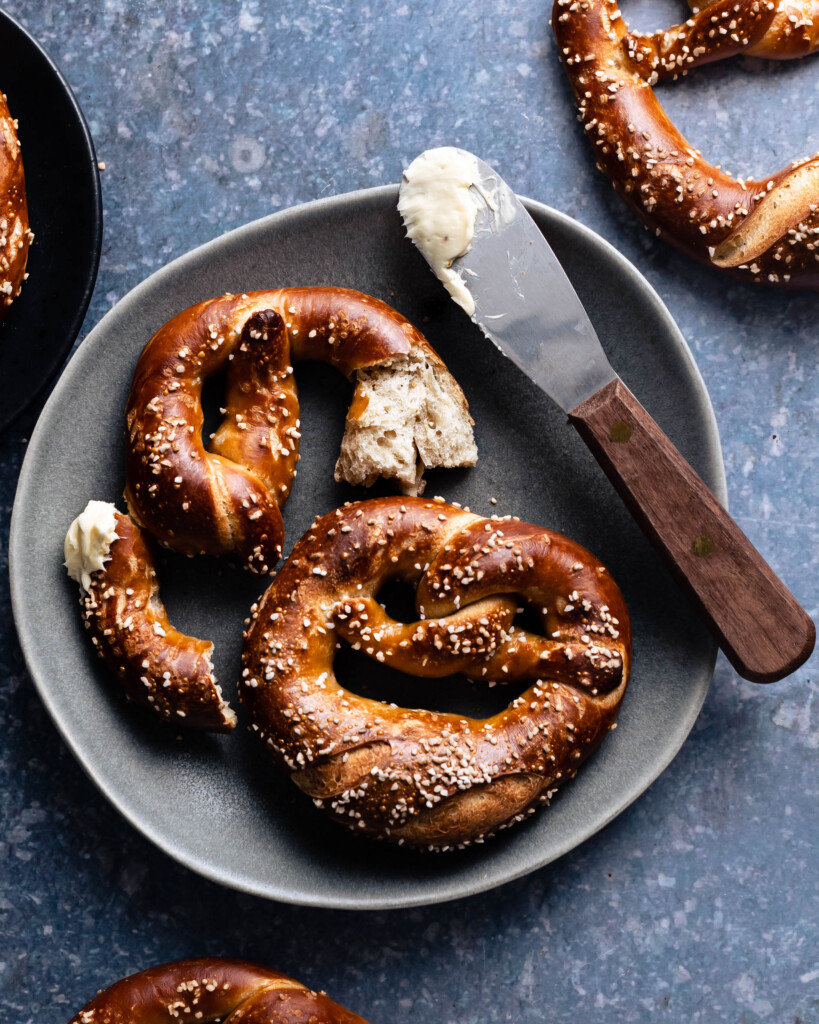 Soft pretzels on a plate with a scraper with a bit of butter