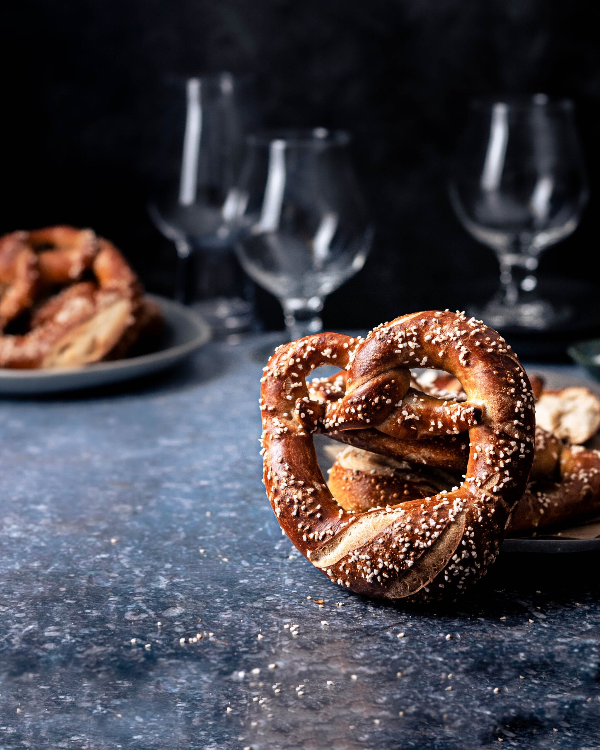 Salted sourdough pretzels with beer glasses in the background