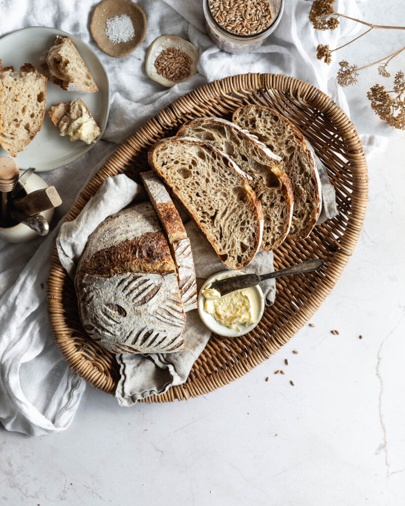 Sliced spelt loaf on a basket with crumb exposed