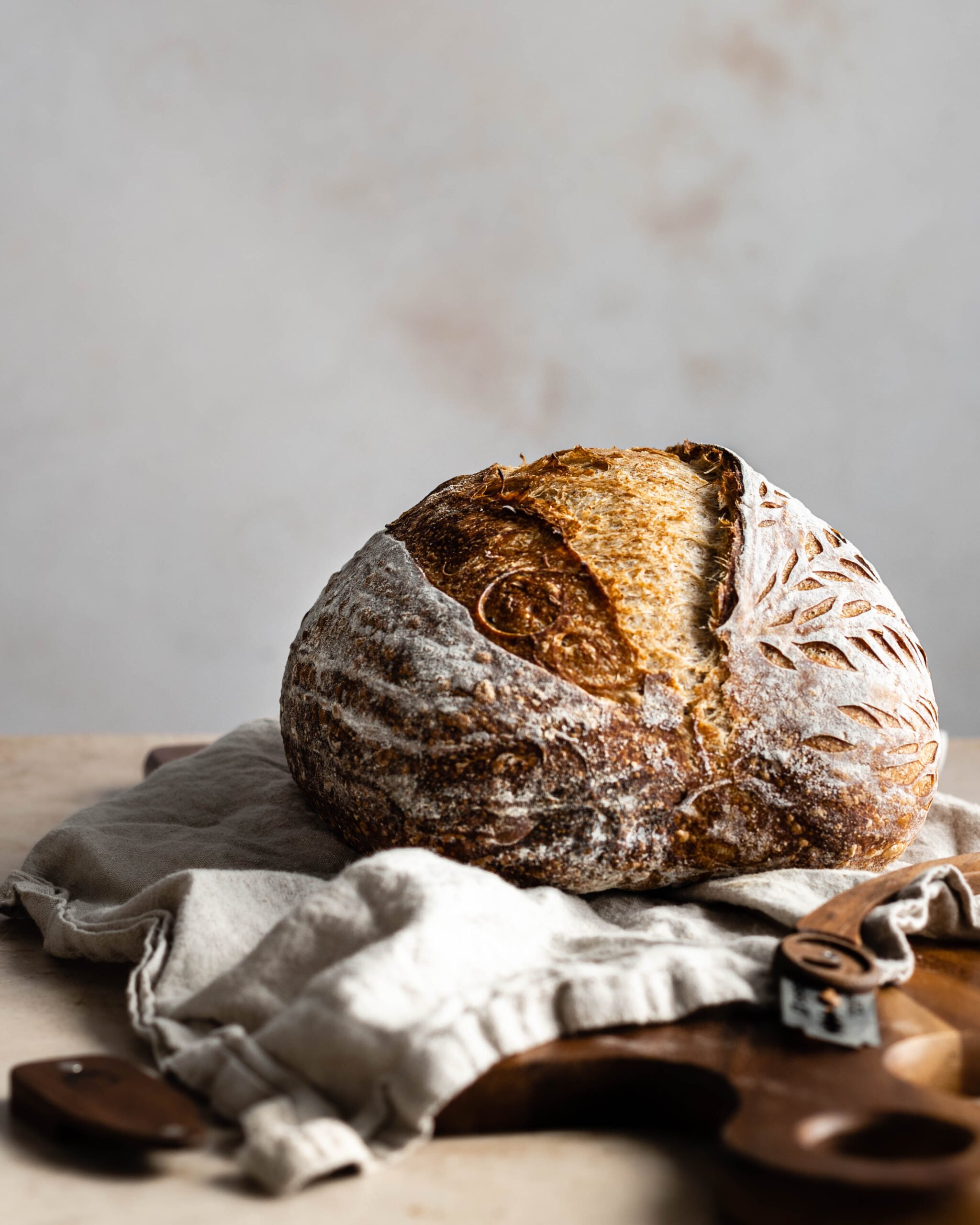 Sourdough bread with an ear on a cutting board and a napkin