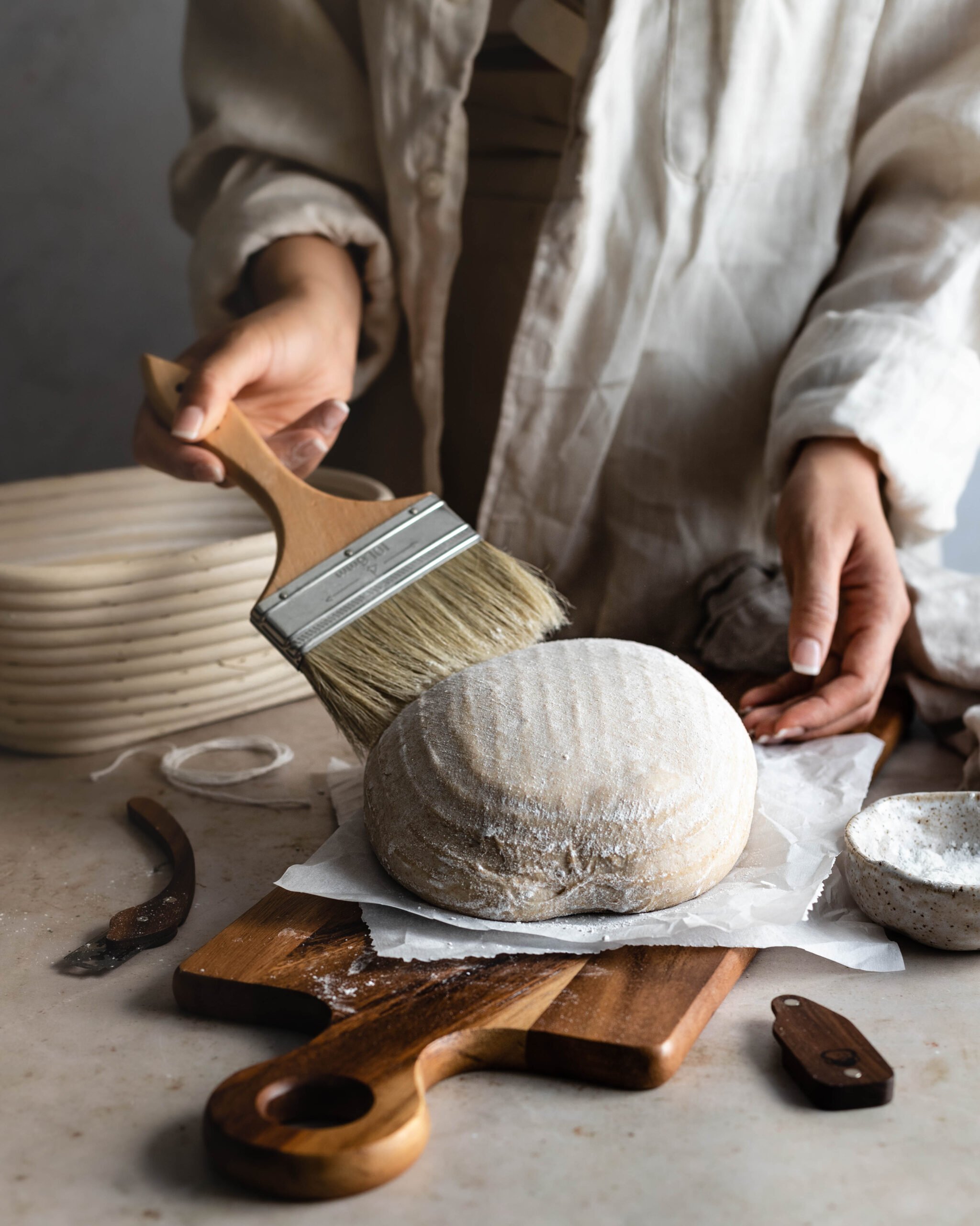 Hand brushing flour off of dough