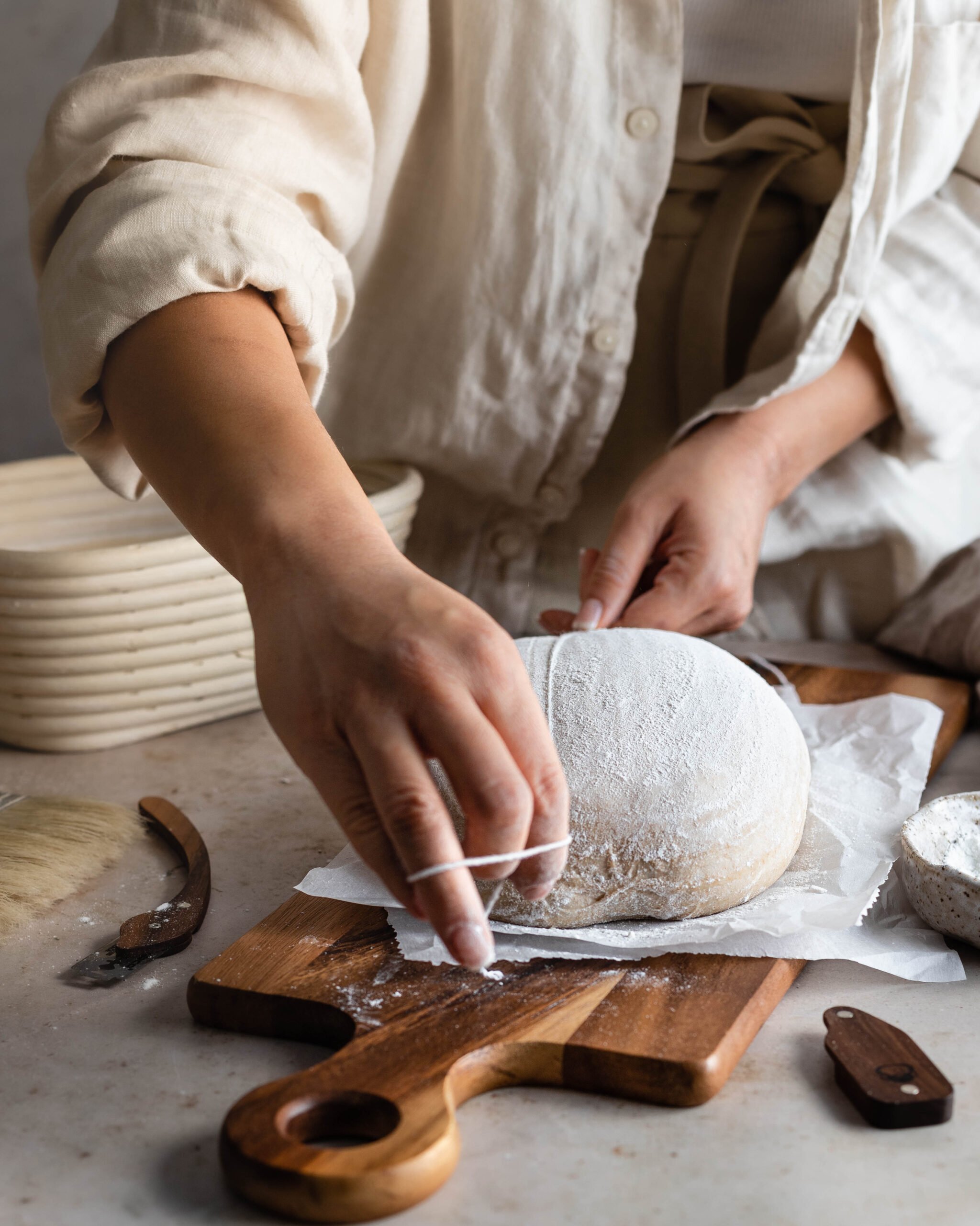 Hands holding string marking dough