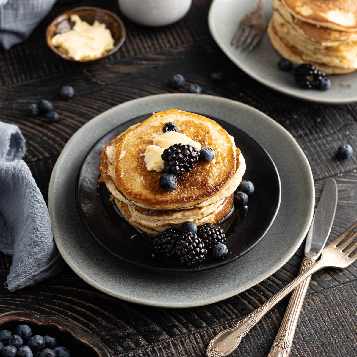 Pancakes on a place served with berries and butter. 