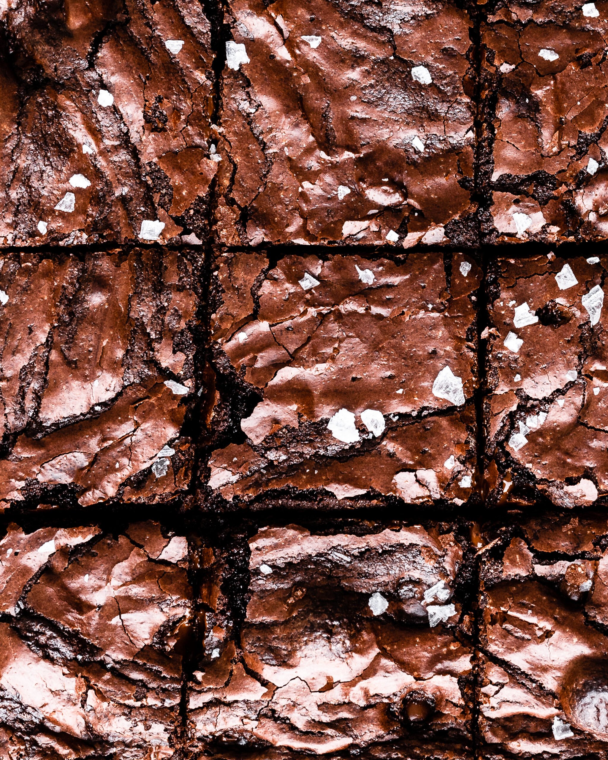 shiny brownies sliced and topped with flaky sea salt