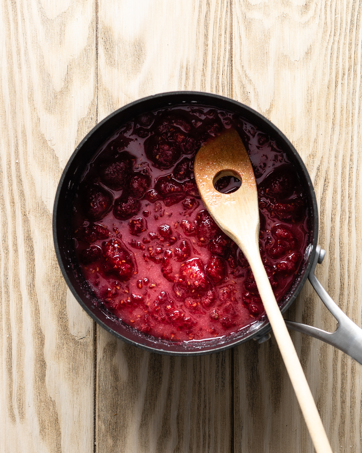 raspberry preserves cooking in a saucepan.