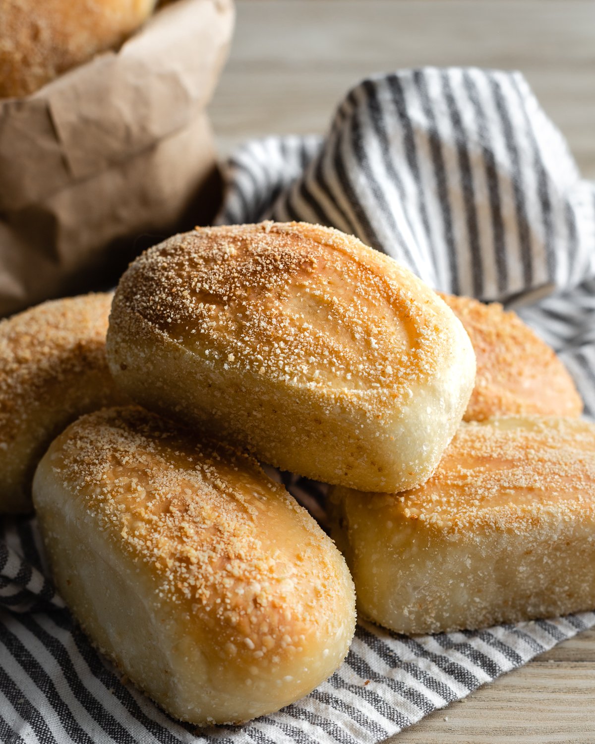 stack of baked pandesal on a striped napkin