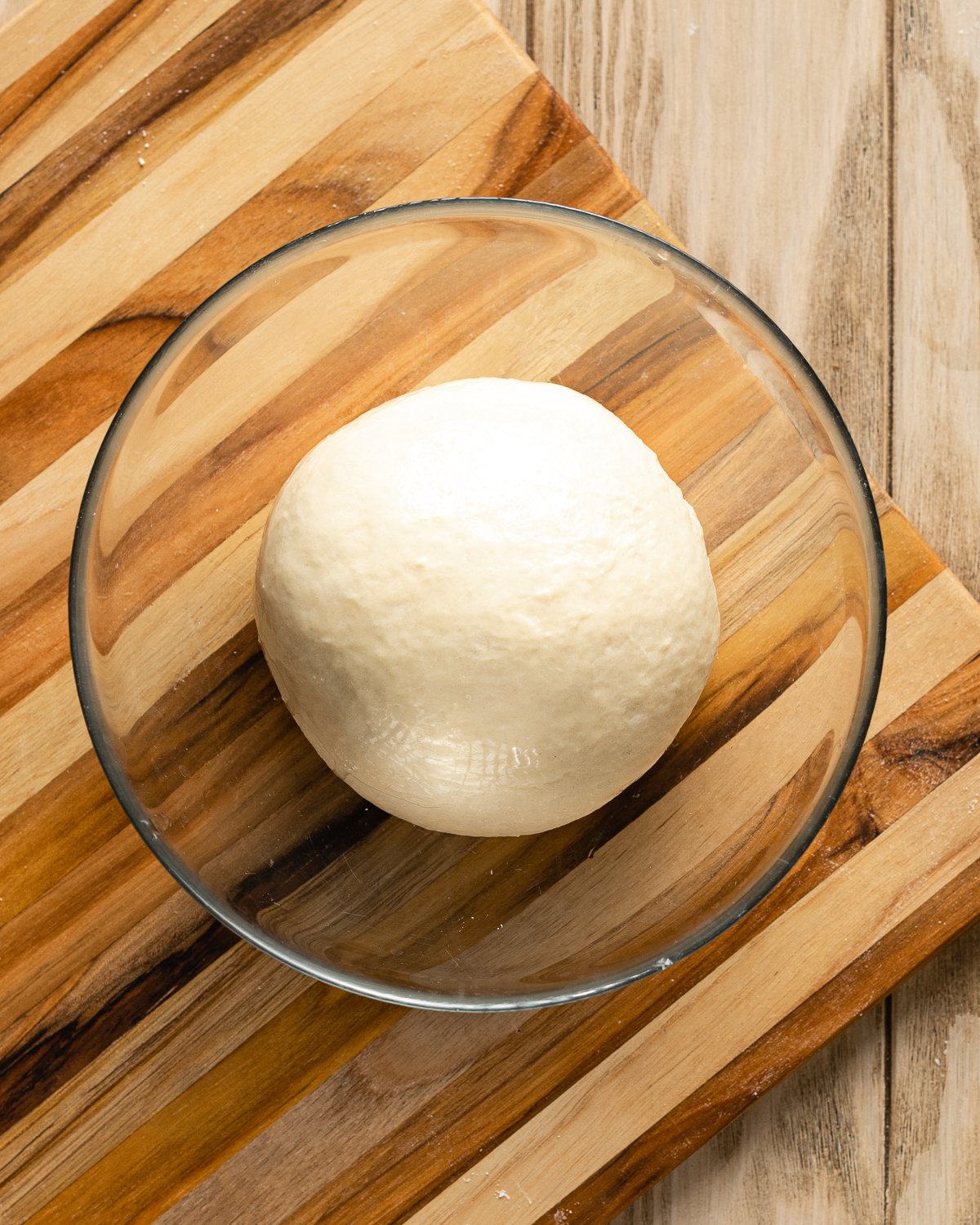 dough in a bowl on a wooden cutting board