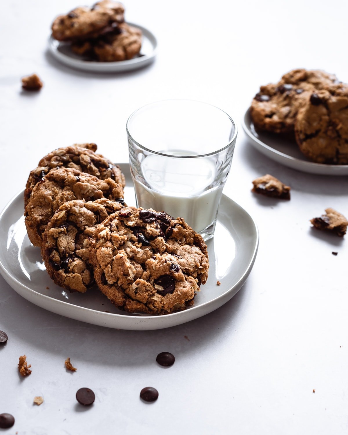 oatmeal cookies on a plate with a cup of milk