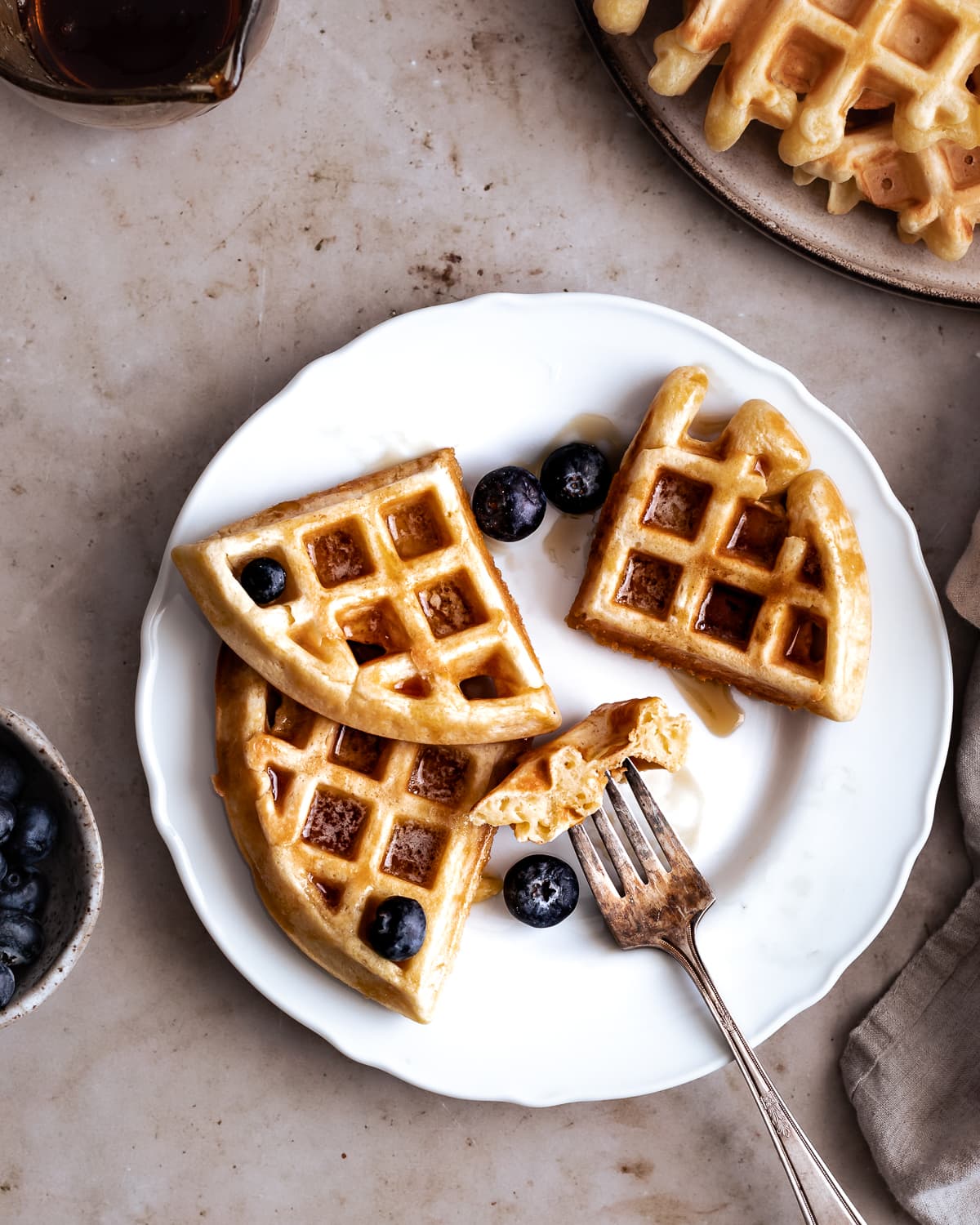 Waffle sliced up with a piece on a fork.