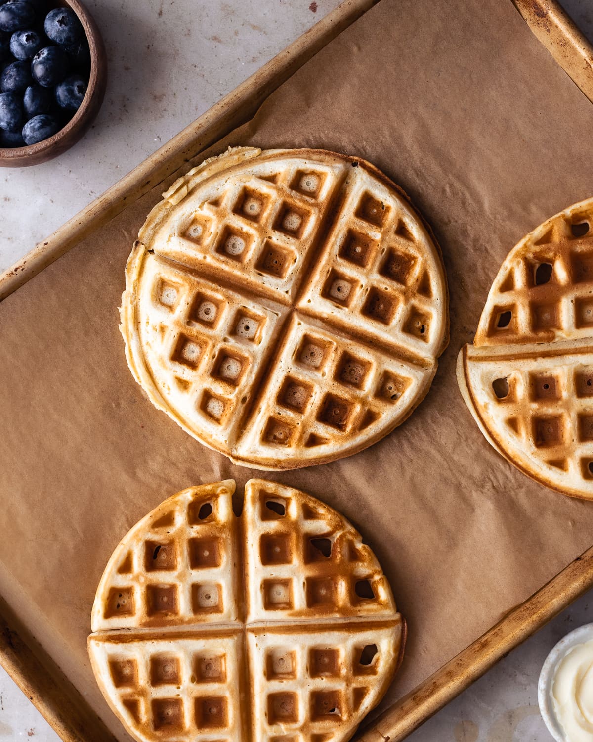 golden brown waffles on a parchment lined baking sheet