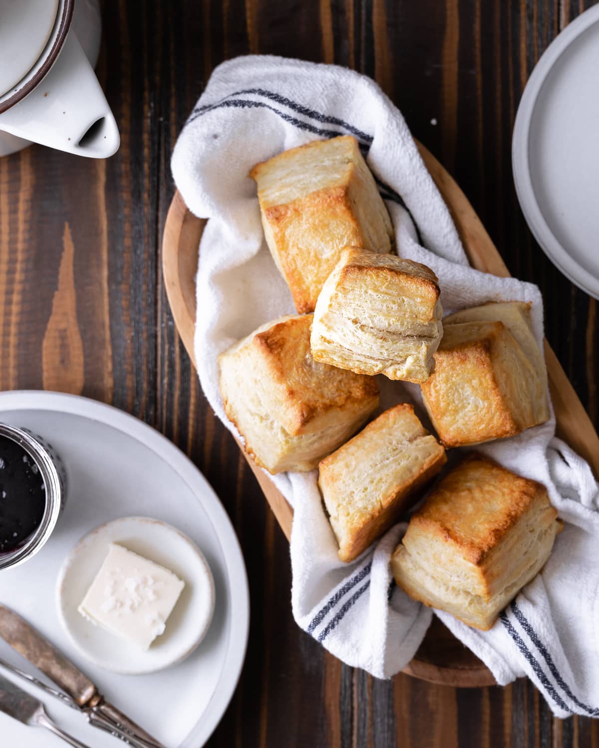 Stack of biscuits on a wooden bowl lined with a tea towel