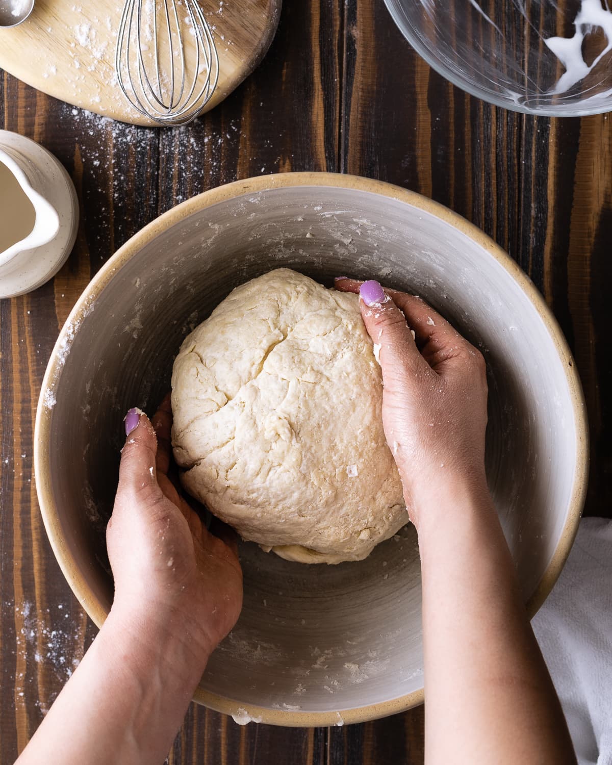 hands kneading biscuit dough. 
