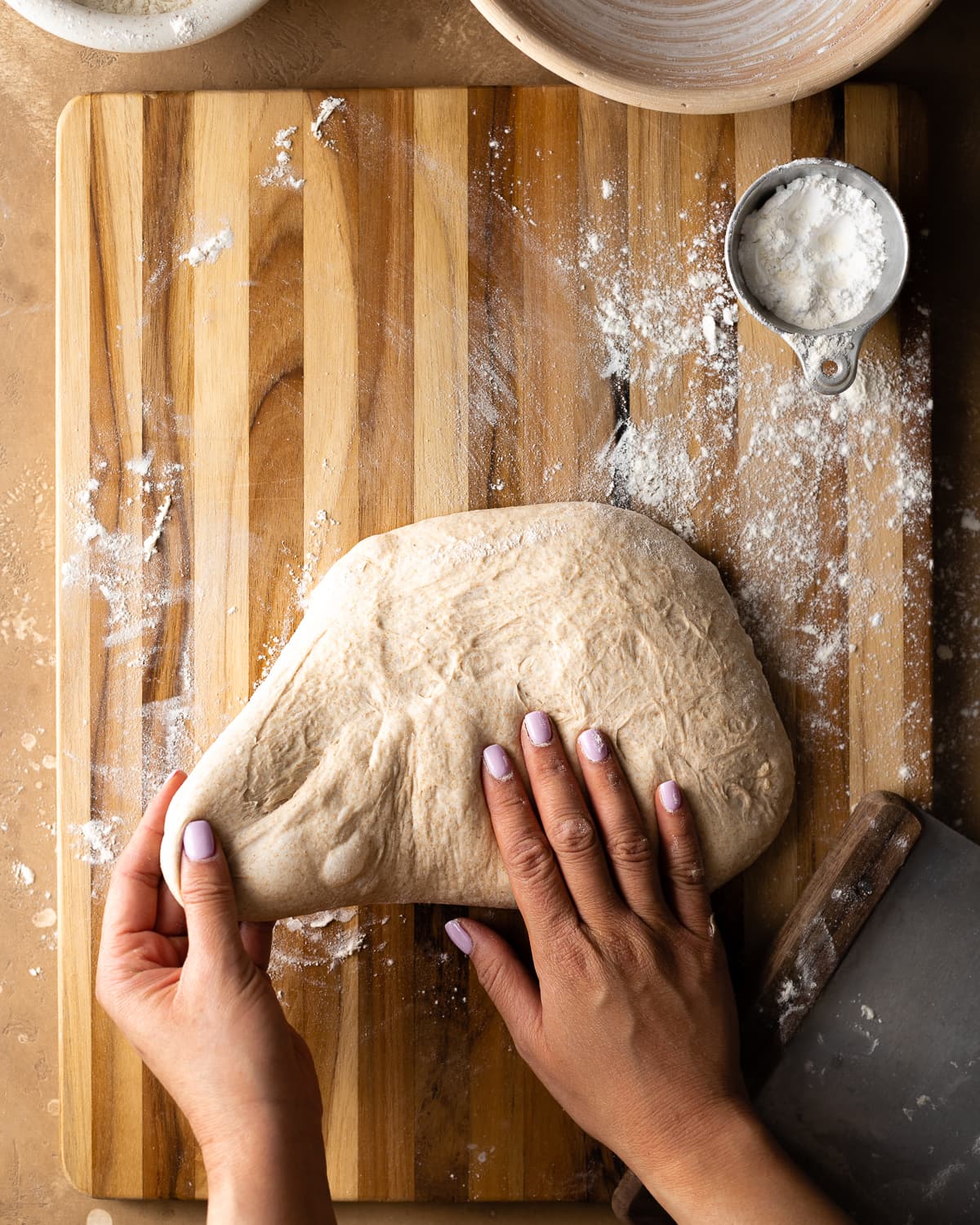 left hand pinching left side of dough and pulling 