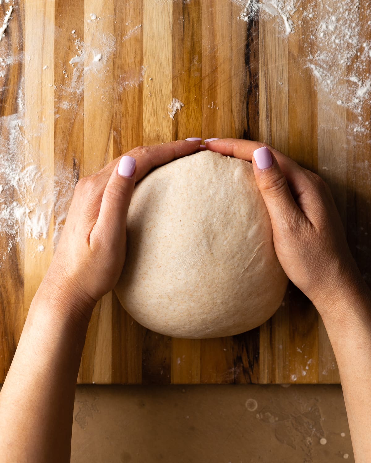 hands cradling dough ball