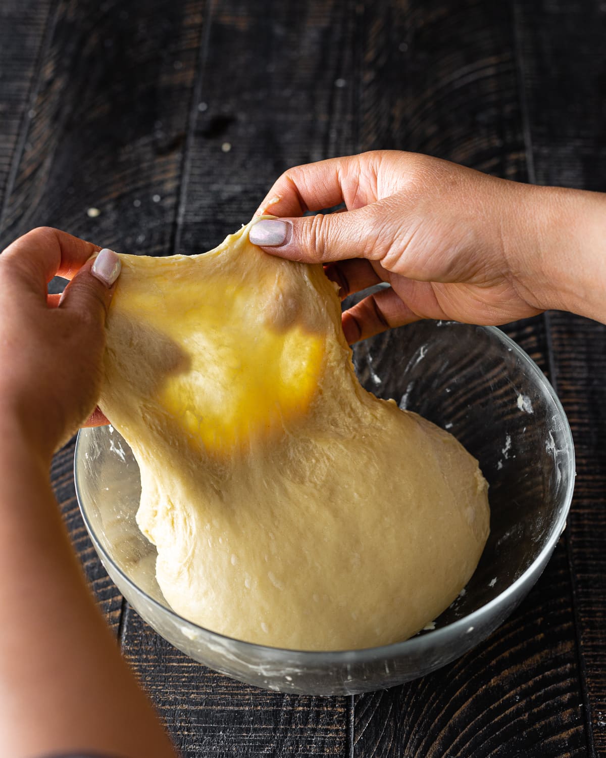 hands stretching dough out thinly until translucent