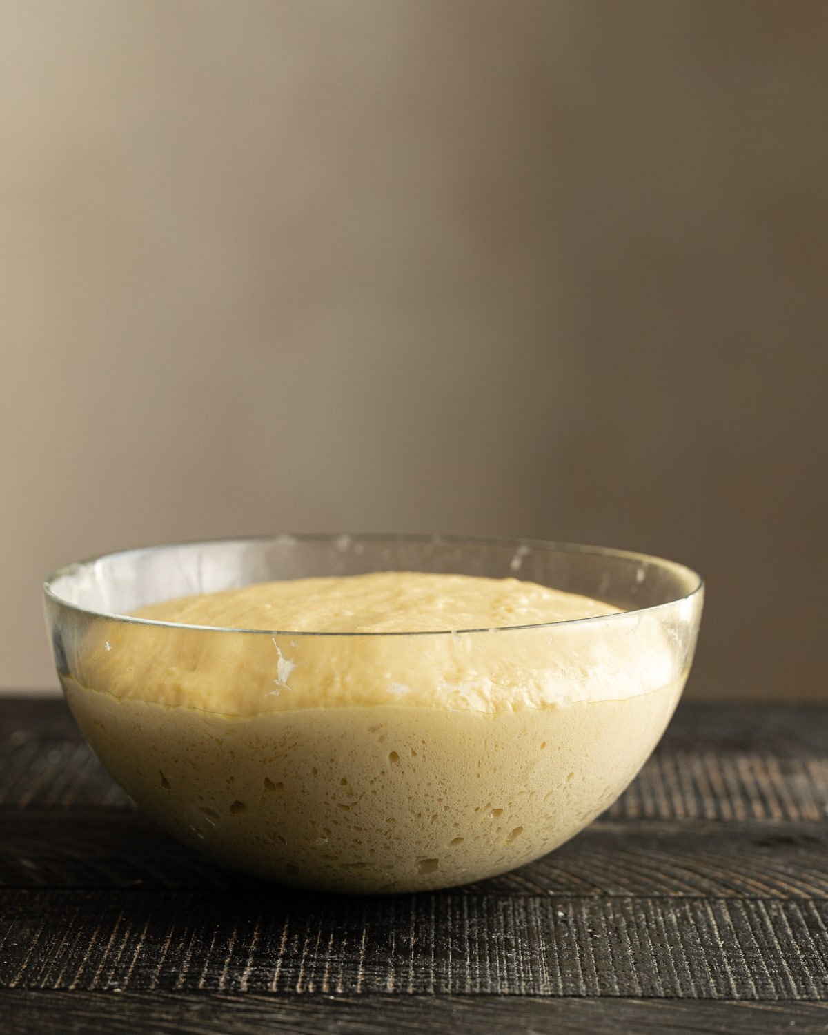 risen sourdough brioche dough inside  glass bowl