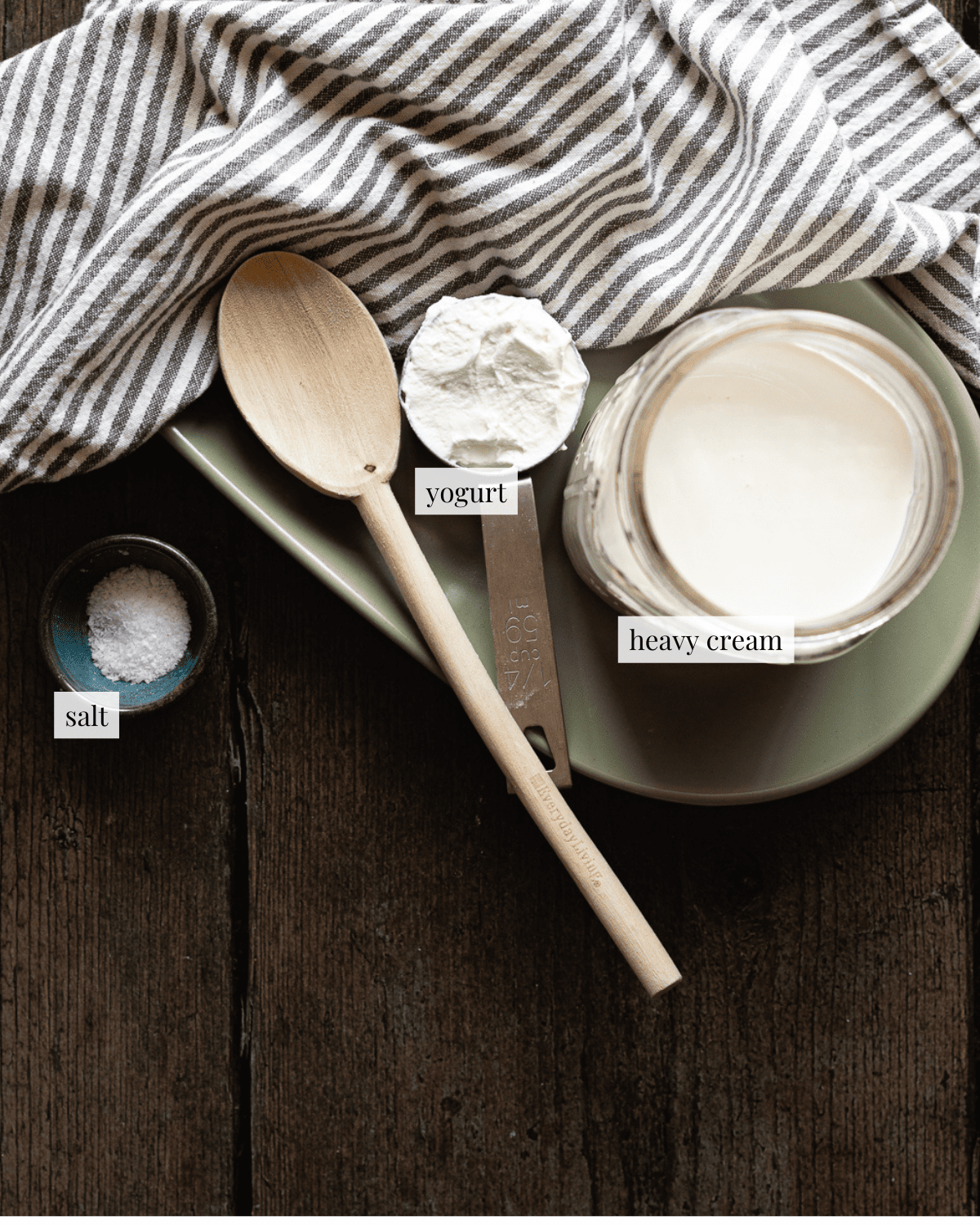 bowl of salt, metal measuring cut with yogurt and jar of heavy cream on a green plate