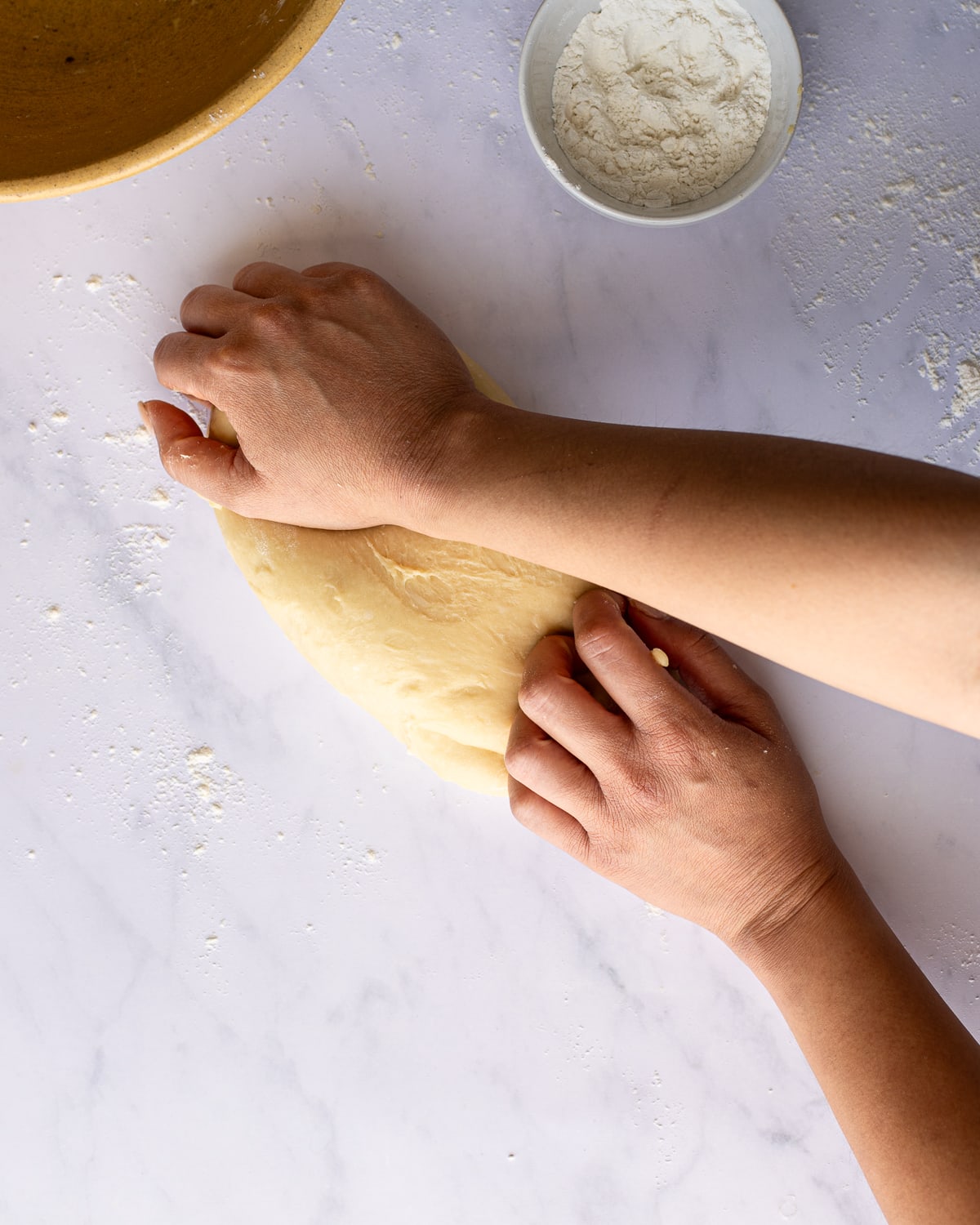 hands kneading dough. 