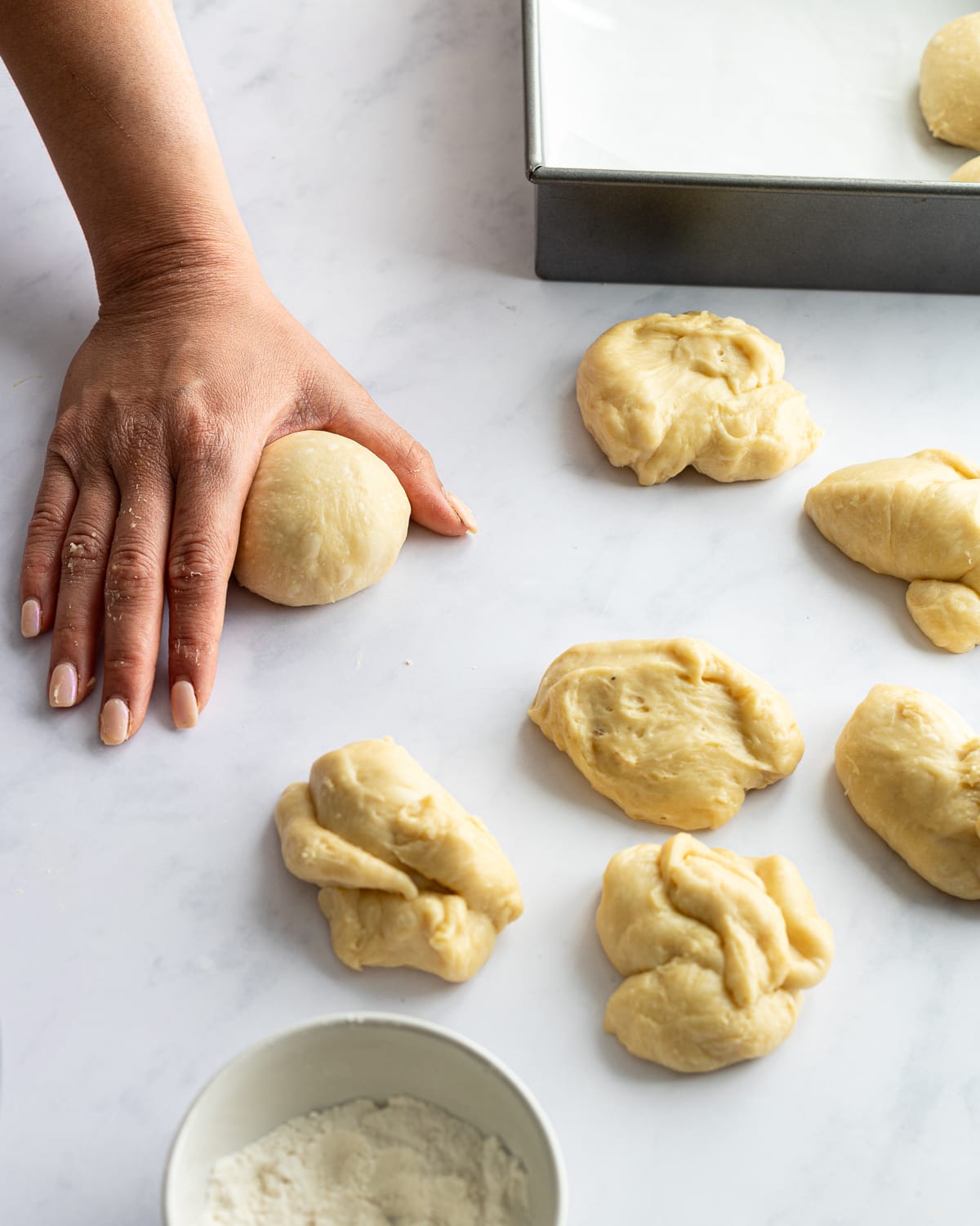 hand cupping a rounded ball of dough. 