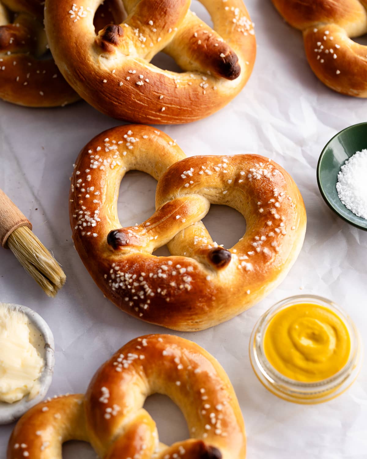 Pretzel topped with salt on a piece of parchment paper. 