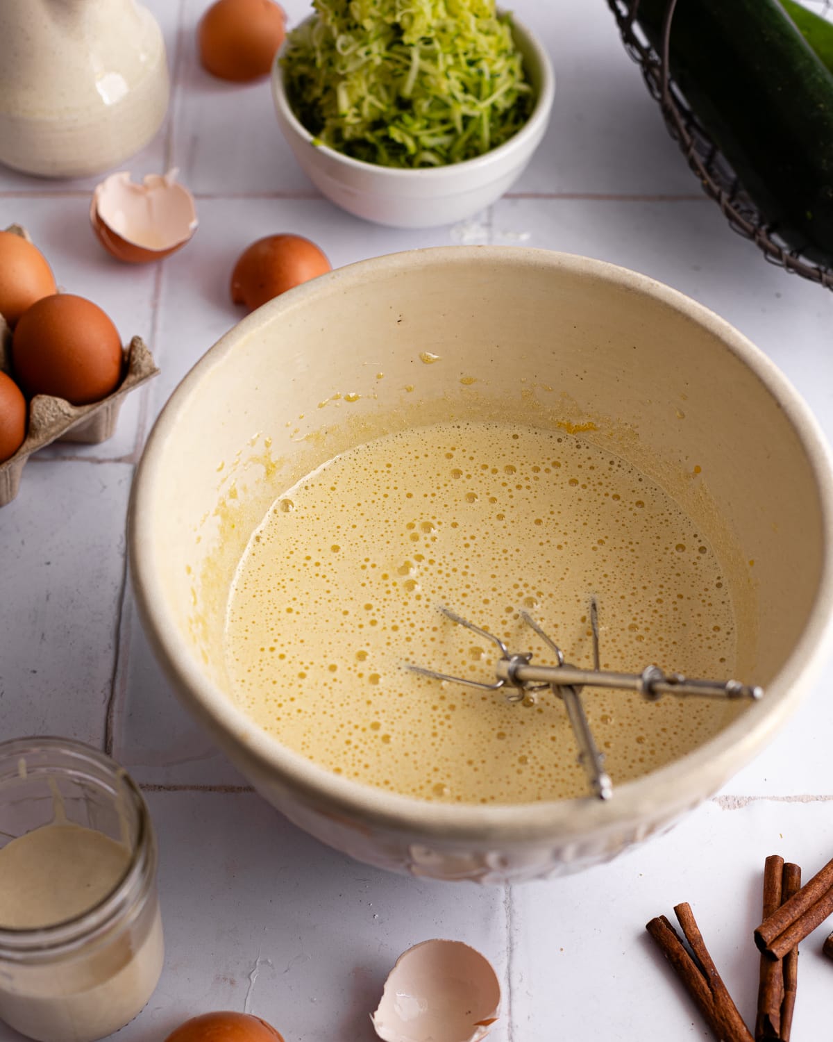 Zucchini bread batter in a white mixing bowl. 