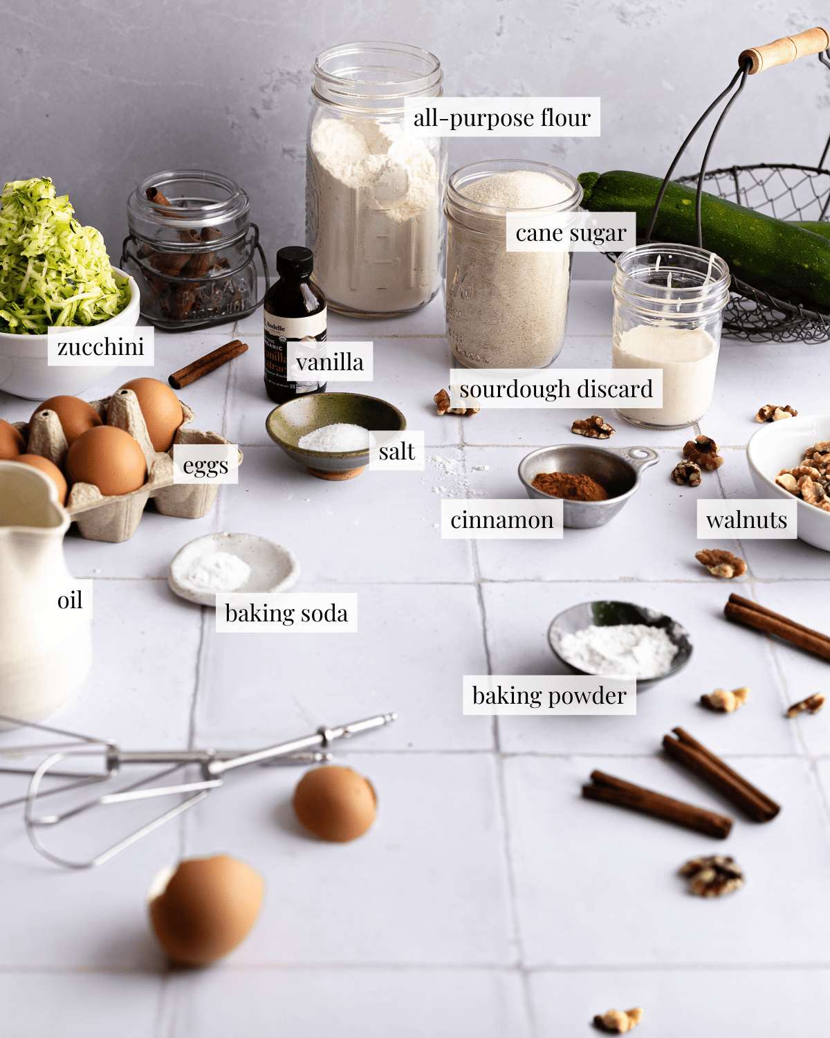 Ingredients for zucchini bread on a tiled surface.