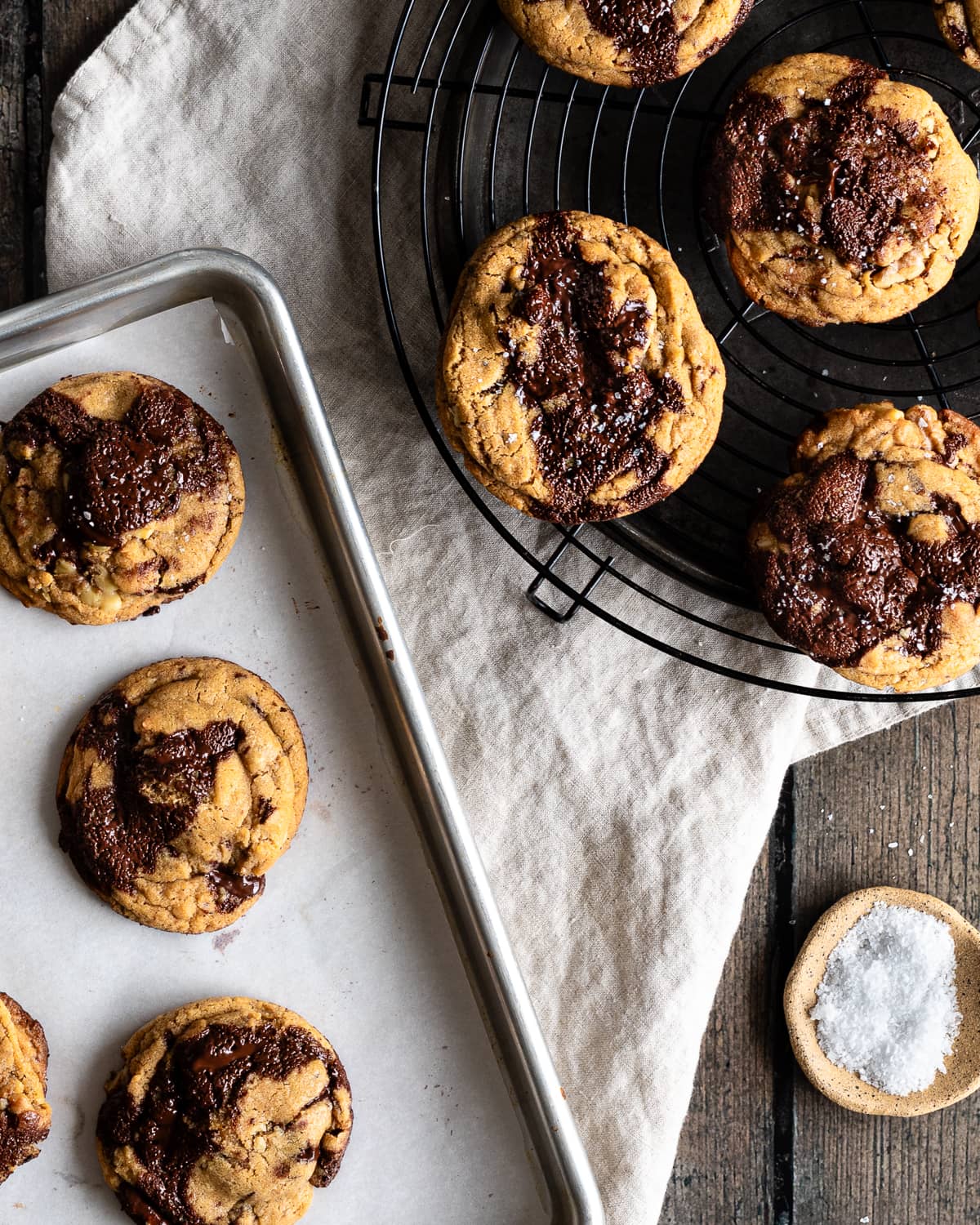 chocolate chip cookies on a wire rack and baking sheet lined with parchment paper. 