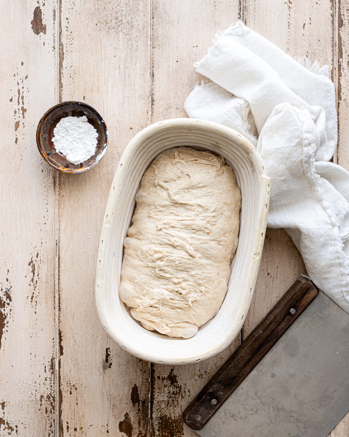 shaped dough inside a oval banneton.