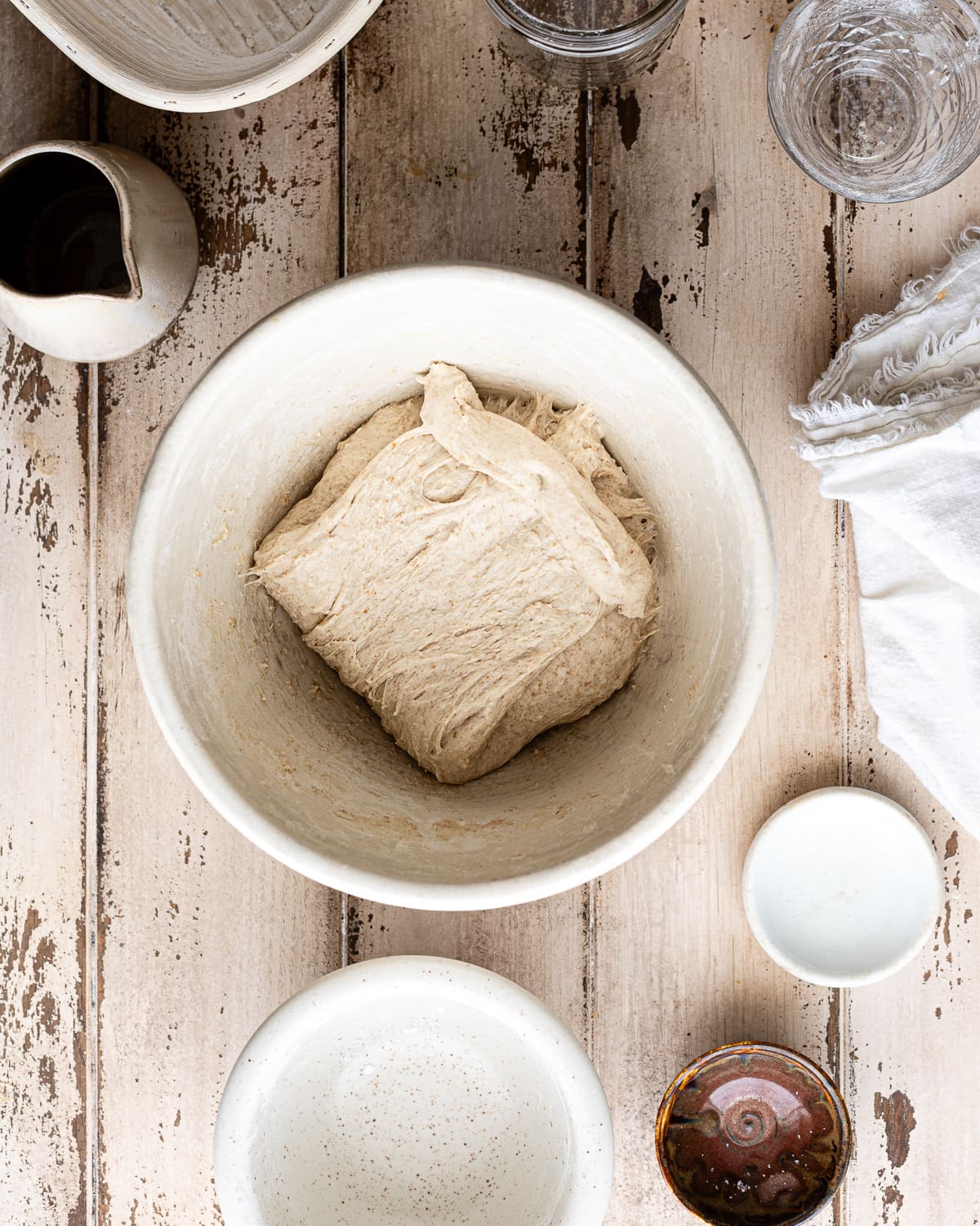 dough folded over itself in. a white mixing bowl. 