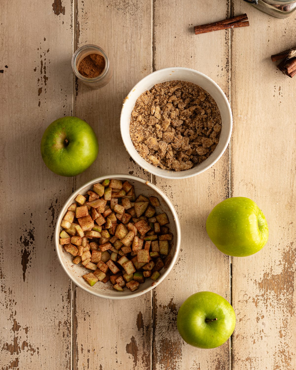 bowl of apples tossed in cinnamon and a bowl of streusel. 