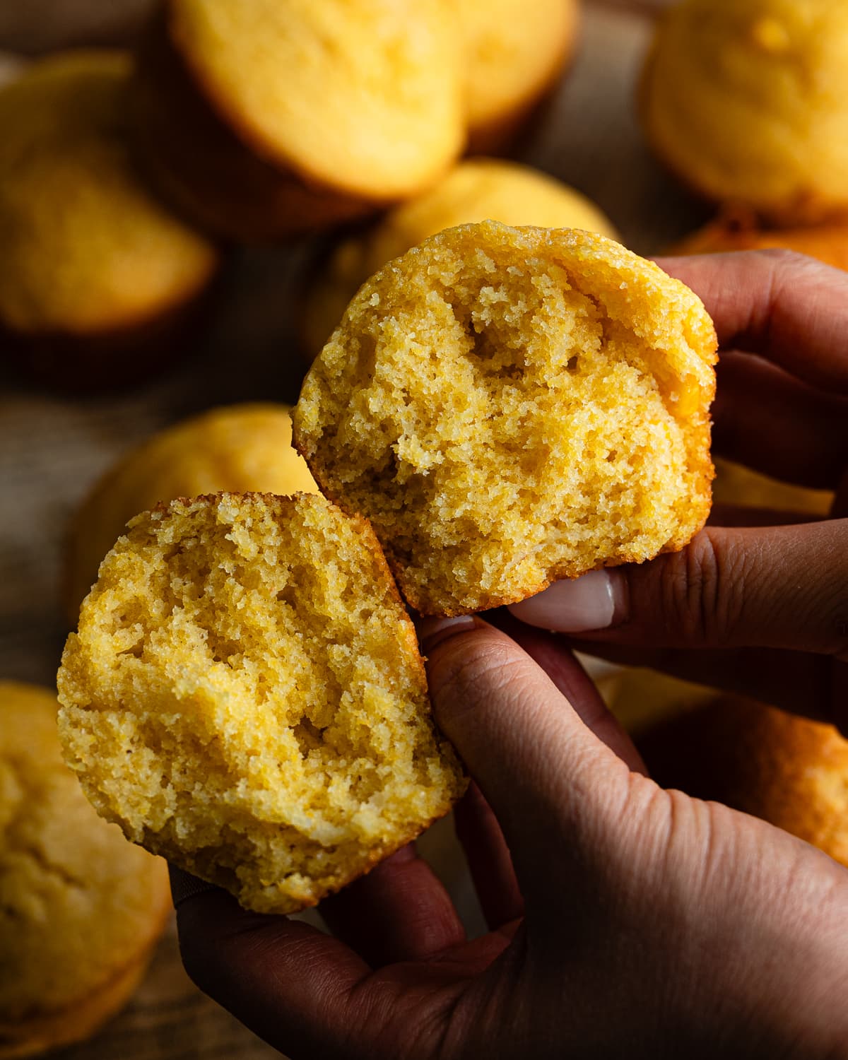 hands holding pumpkin muffin cut in half.