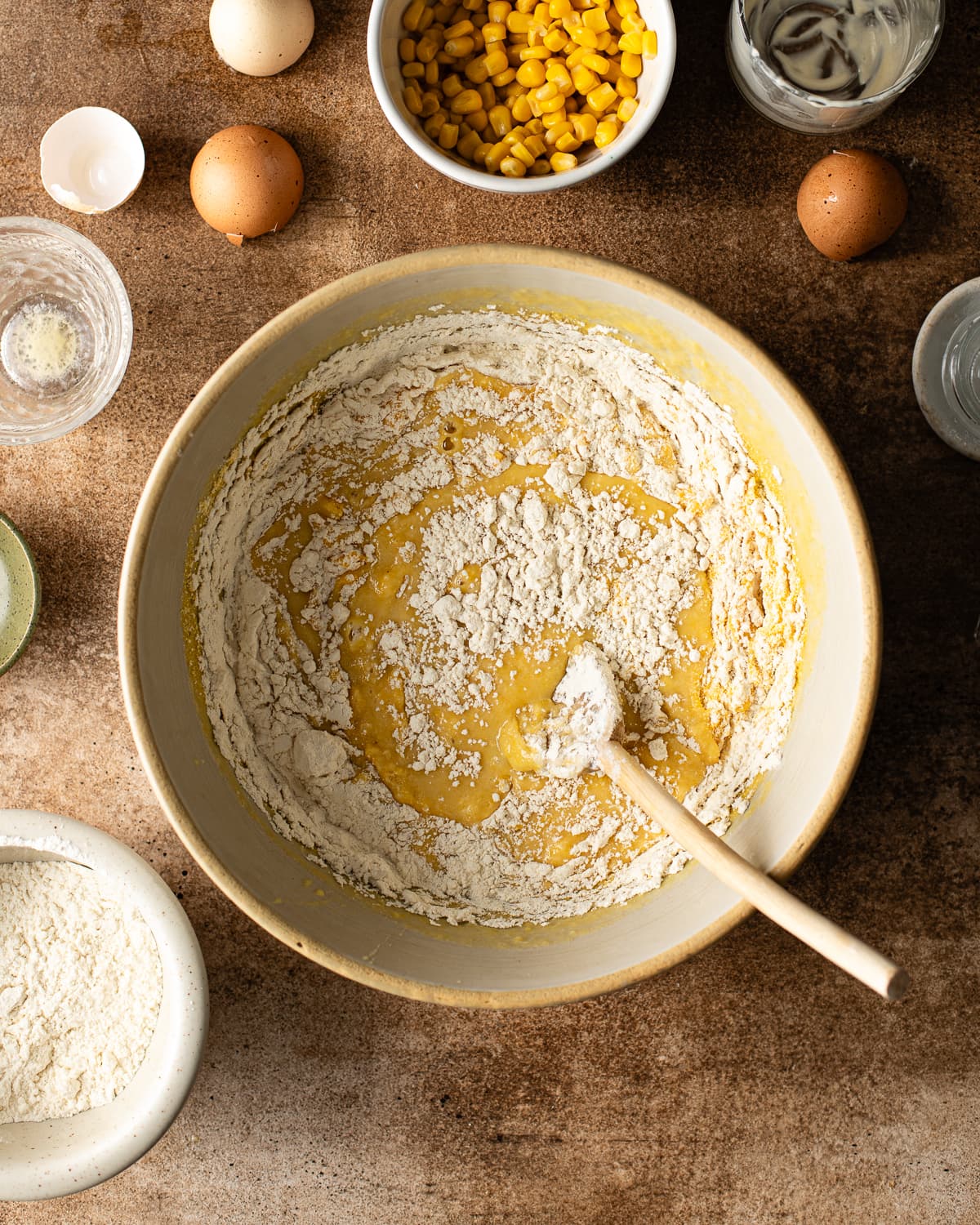 flour being mixed into corn muffin batter. 