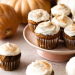Pumpkin cupcakes with frosting on a cake stand.