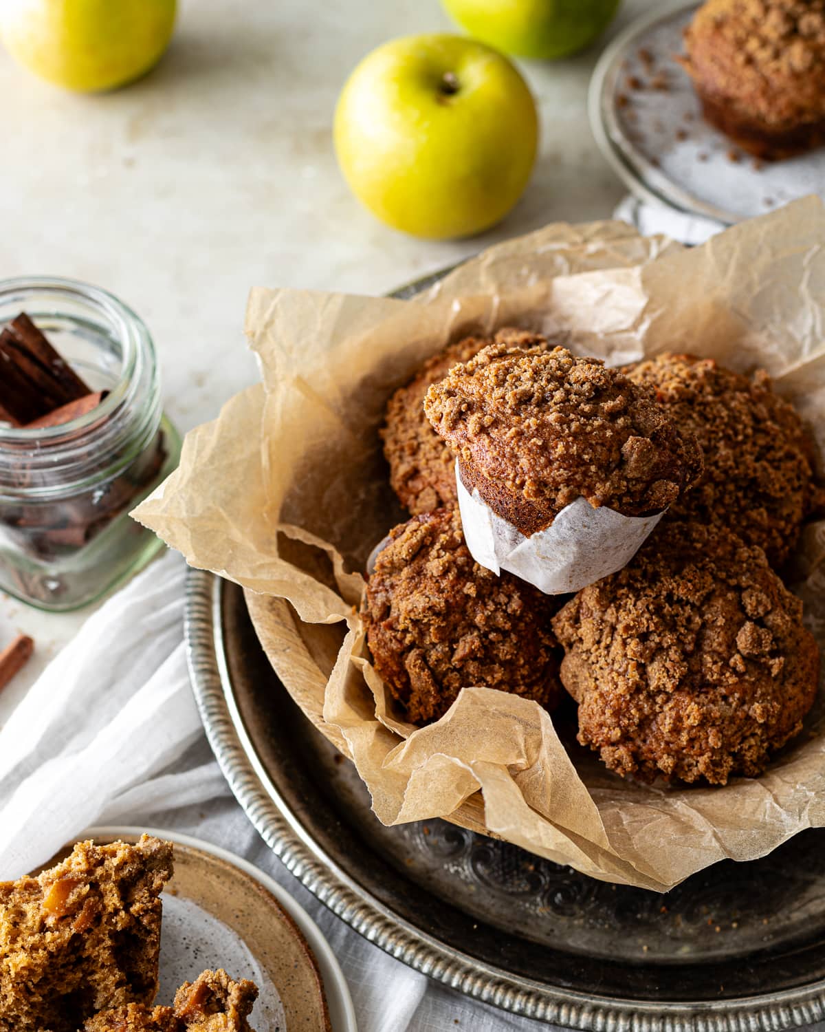 Basket of apple muffins in a parchment-lined wood bowl.