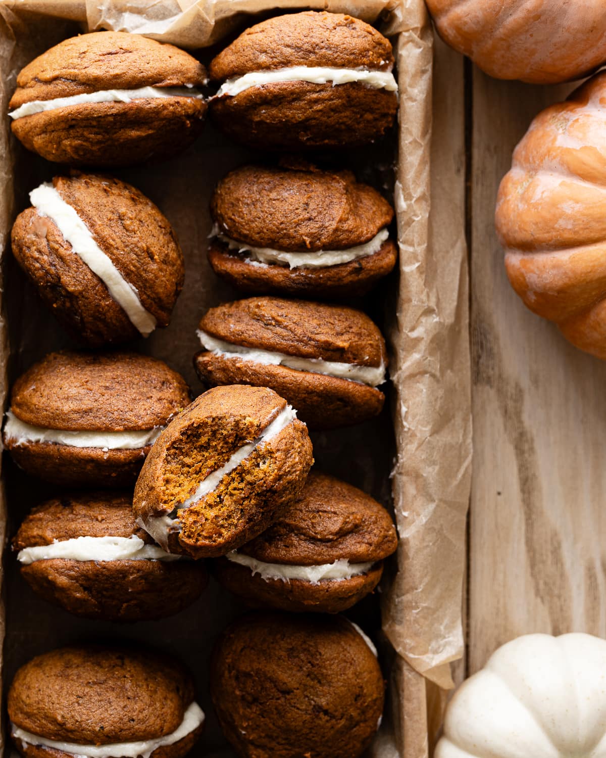 wooden tray with rows of pumpkin whoopie pies.