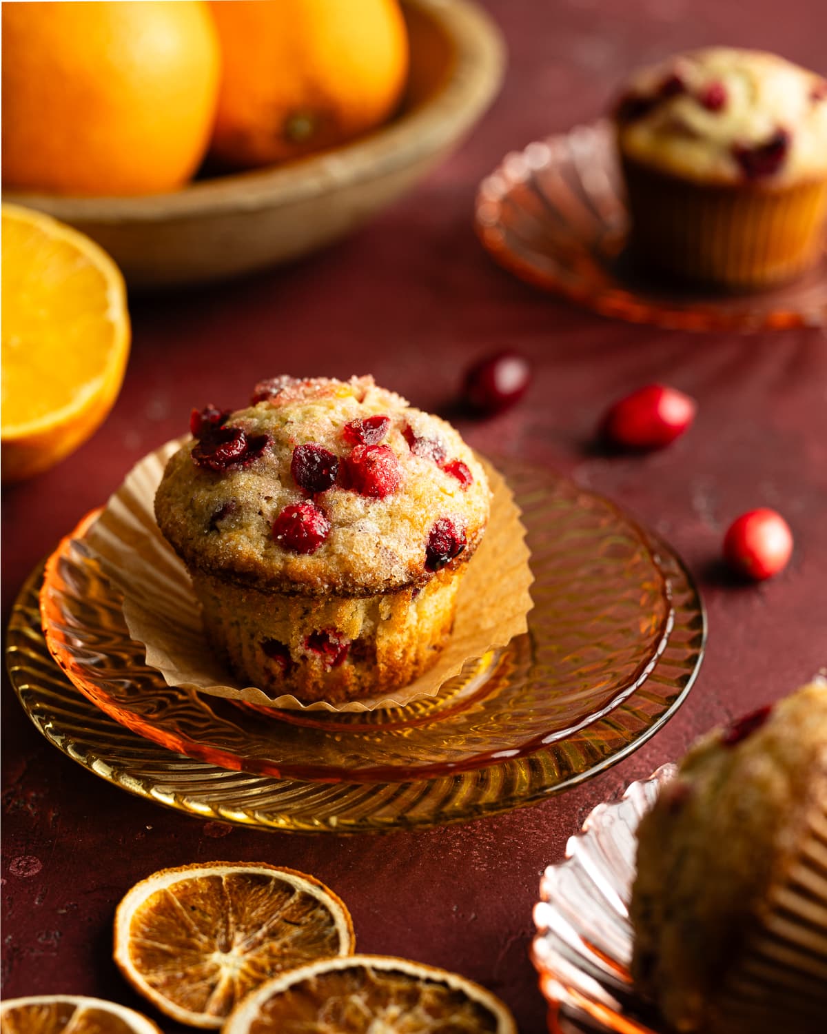 Cranberry Muffin with the wrapper peeled back on a saucer. 