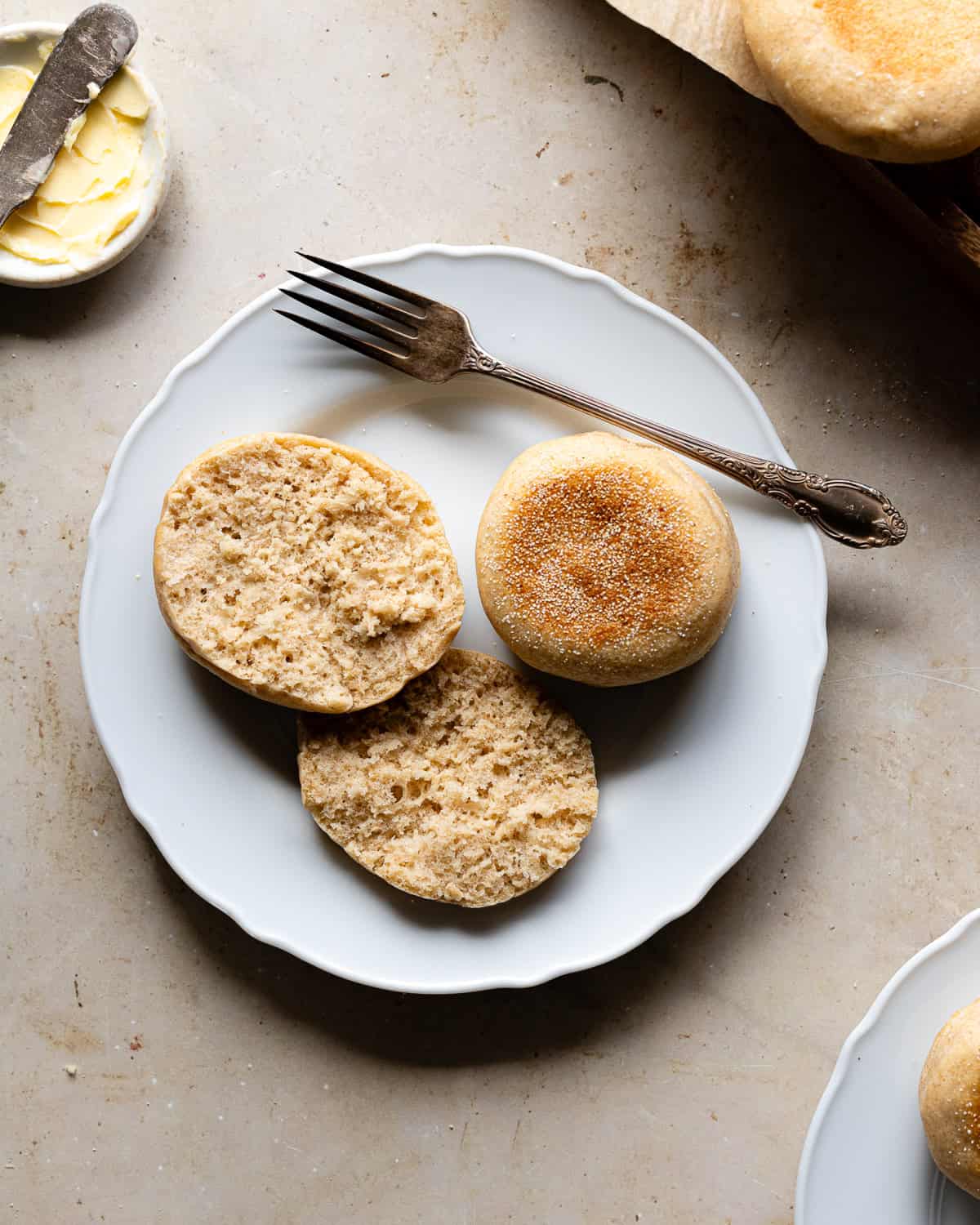 Sliced untoasted English muffins on a plate. 