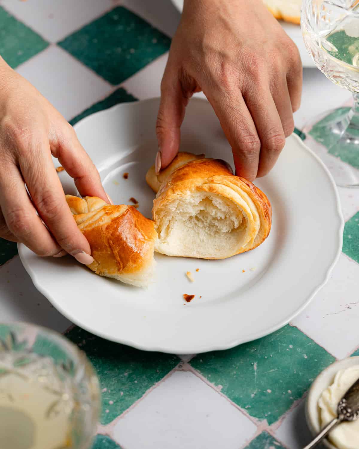 Torn crescent roll on a white plate. 