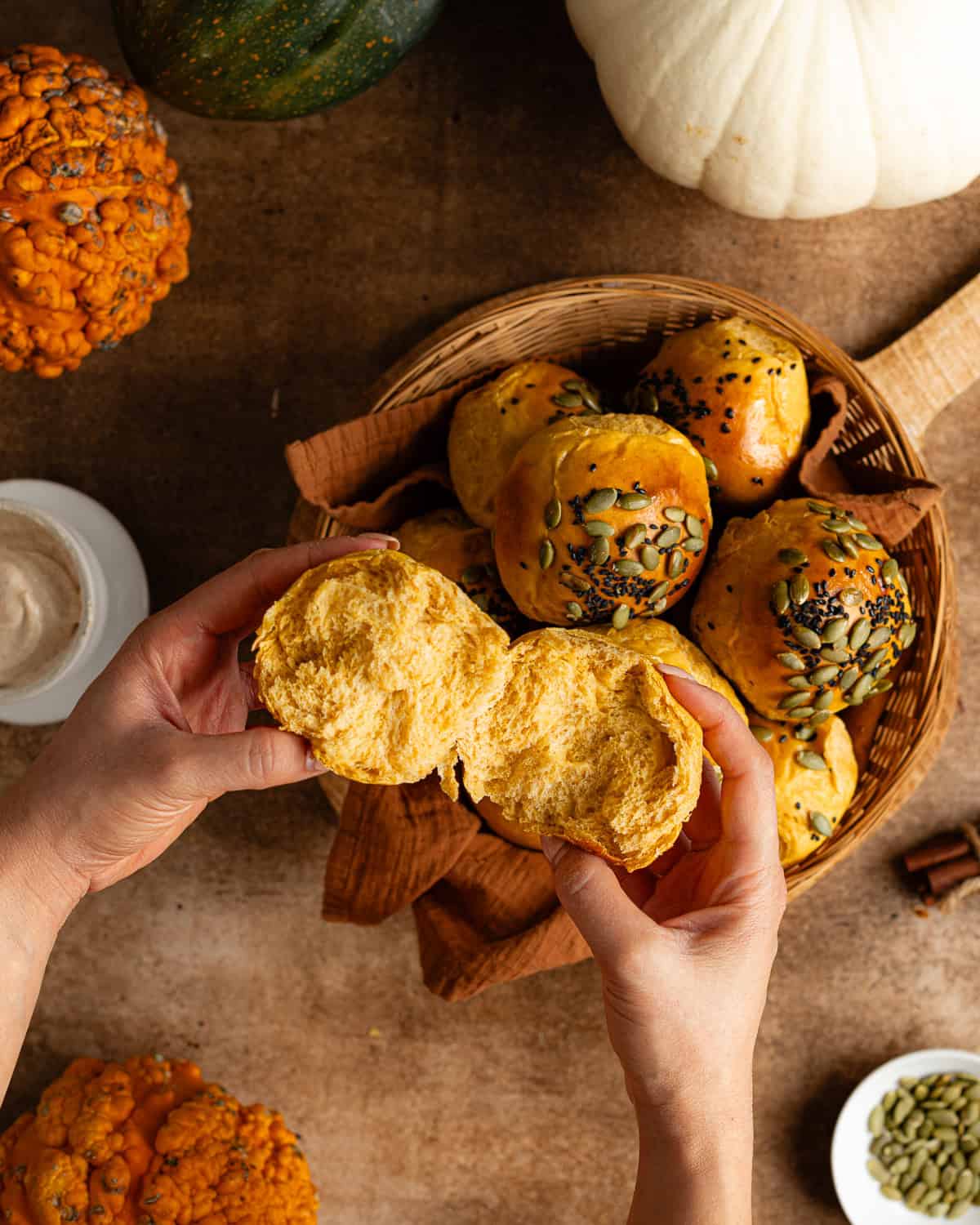 Hands tearing open a bread roll. 