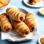 Pretzel Dogs stacked on a platter lined with parchment paper.