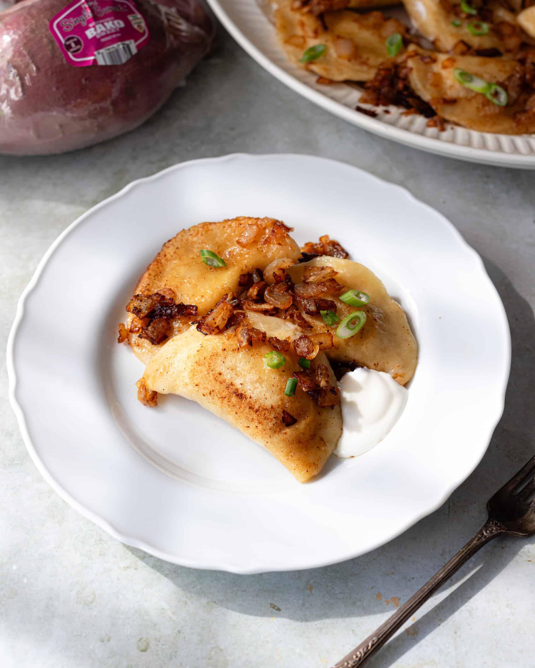 Plate with three pierogi on top. 