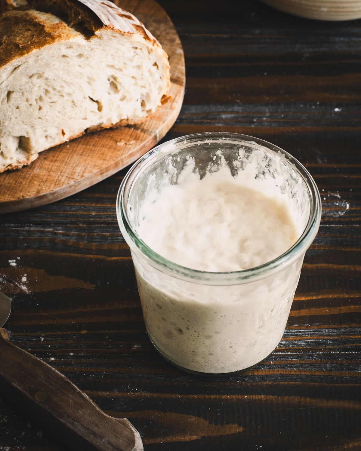 Sourdough starter and all-purpose flour on cutting board.
